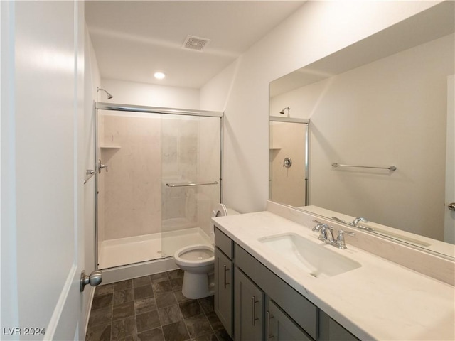 bathroom with vanity, toilet, and a shower with shower door