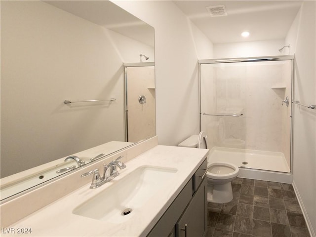 bathroom with vanity, toilet, and a shower with door