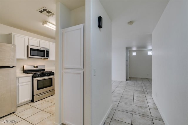 kitchen featuring white cabinets, light tile patterned floors, and appliances with stainless steel finishes