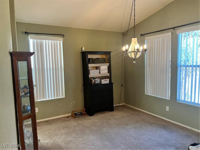 empty room with plenty of natural light, carpet, vaulted ceiling, and a notable chandelier