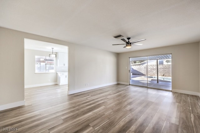 spare room with hardwood / wood-style floors, ceiling fan, and a textured ceiling