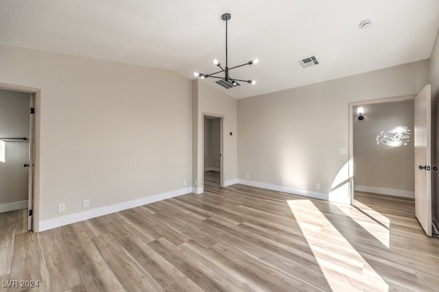 interior space with light hardwood / wood-style floors, lofted ceiling, and a chandelier