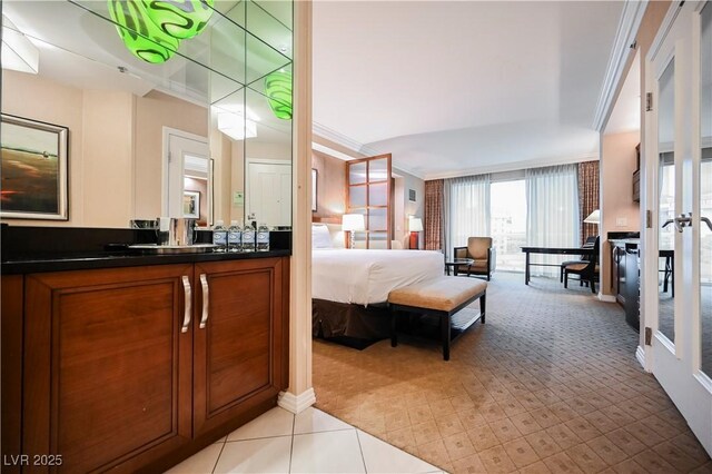 135 E Harmon Ave Unit 407, Las Vegas, NV 89109 - bedroom featuring light carpet, crown molding, a sink, and baseboards