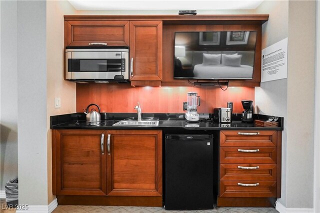135 E Harmon Ave Unit 407, Las Vegas, NV 89109 - kitchen with stainless steel microwave, dark countertops, dishwashing machine, and a sink