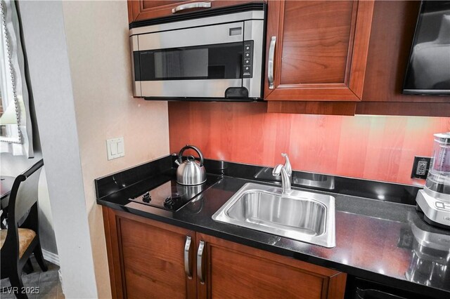 135 E Harmon Ave Unit 407, Las Vegas, NV 89109 - kitchen featuring stainless steel microwave, brown cabinets, and a sink