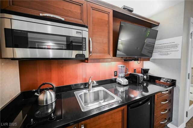 135 E Harmon Ave Unit 407, Las Vegas, NV 89109 - kitchen featuring brown cabinets, dark countertops, dishwasher, a sink, and stainless steel microwave
