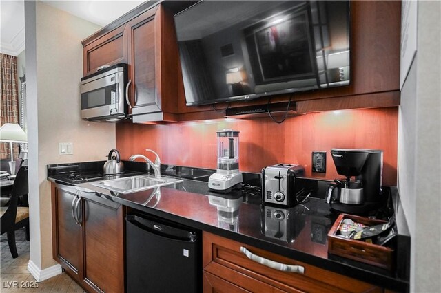 135 E Harmon Ave Unit 407, Las Vegas, NV 89109 - kitchen with dark countertops, dishwasher, a sink, and stainless steel microwave