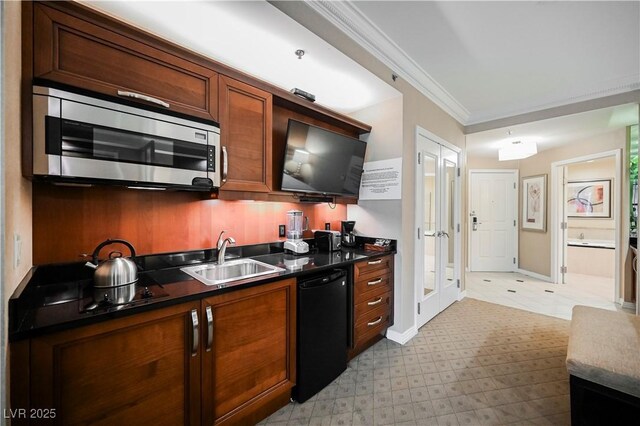 135 E Harmon Ave Unit 407, Las Vegas, NV 89109 - kitchen featuring dark countertops, a sink, stainless steel microwave, baseboards, and ornamental molding