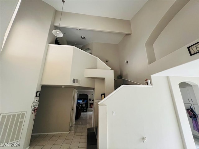 washroom featuring light tile patterned flooring and a high ceiling