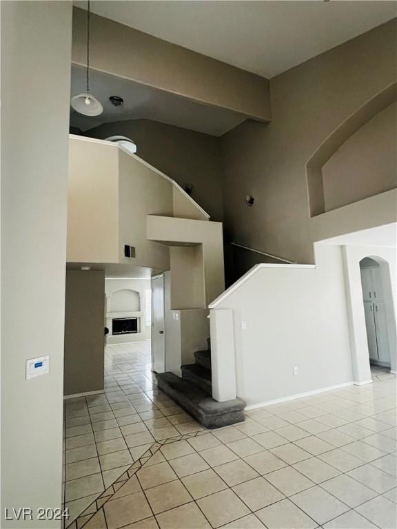 stairs with tile patterned floors and a high ceiling