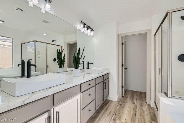 bathroom featuring a shower with door, vanity, and hardwood / wood-style floors