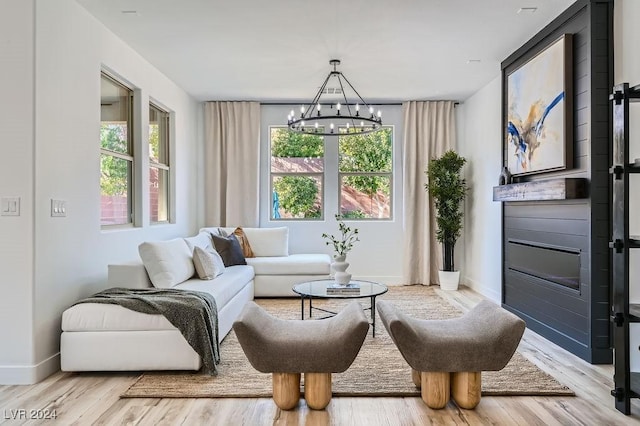 sitting room with a healthy amount of sunlight, a chandelier, and light hardwood / wood-style flooring