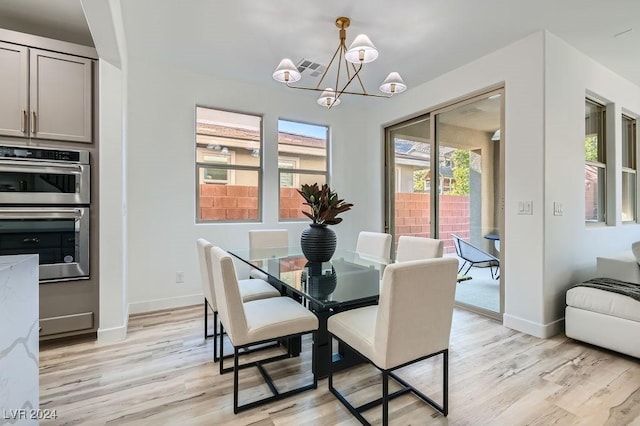 dining space with a chandelier and light hardwood / wood-style floors