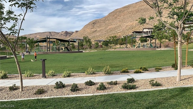 view of community with a yard, a playground, and a mountain view