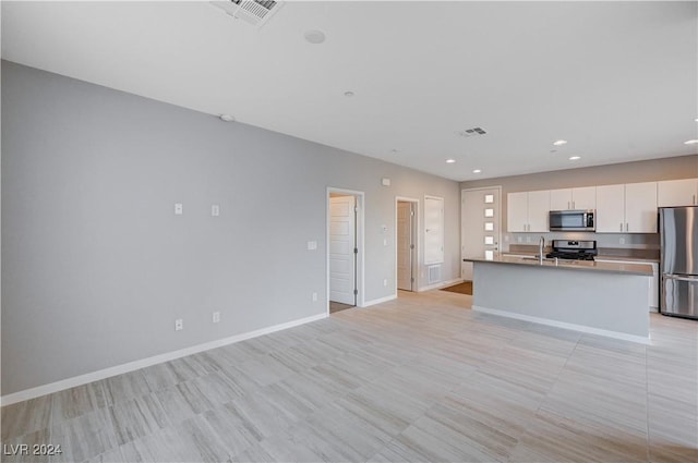 kitchen with white cabinets, sink, a kitchen island with sink, and appliances with stainless steel finishes