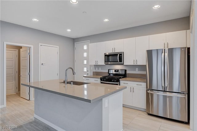 kitchen featuring white cabinetry, an island with sink, appliances with stainless steel finishes, and sink