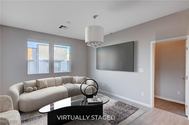 living room with light wood-type flooring and a chandelier