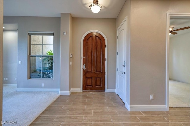 entryway featuring ceiling fan and light colored carpet