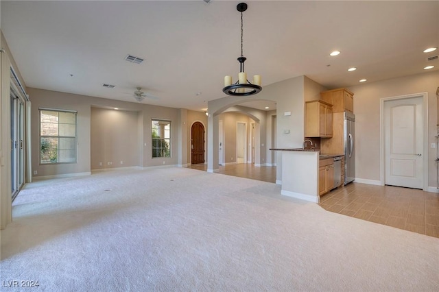 unfurnished living room with light carpet and ceiling fan