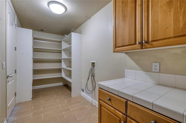 laundry room with cabinets, a textured ceiling, and washer hookup