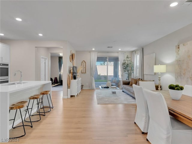 living room with sink and light hardwood / wood-style flooring