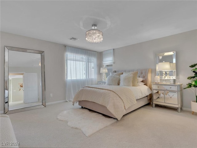 carpeted bedroom with a notable chandelier