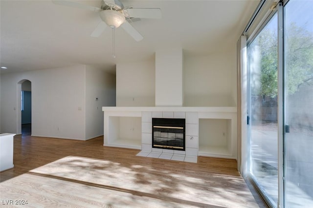 unfurnished living room with hardwood / wood-style flooring, ceiling fan, and a fireplace