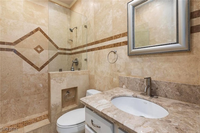 bathroom featuring vanity, toilet, and a tile shower