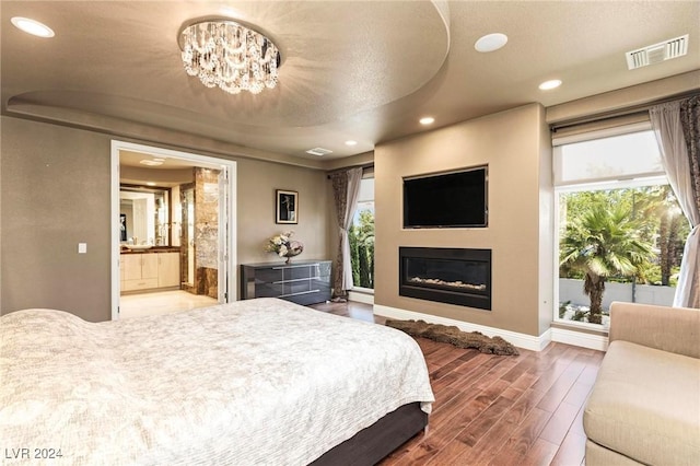 bedroom with ensuite bathroom and an inviting chandelier