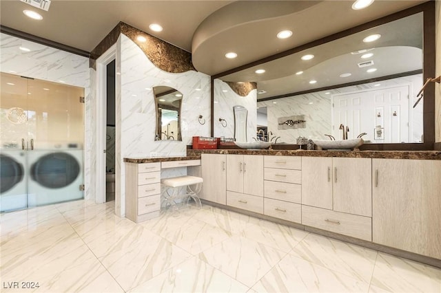 bathroom with vanity, washer / clothes dryer, and tile walls