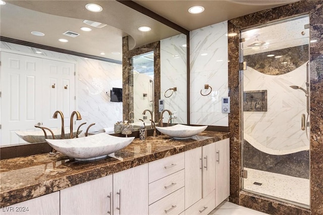 bathroom featuring walk in shower, vanity, and tile walls