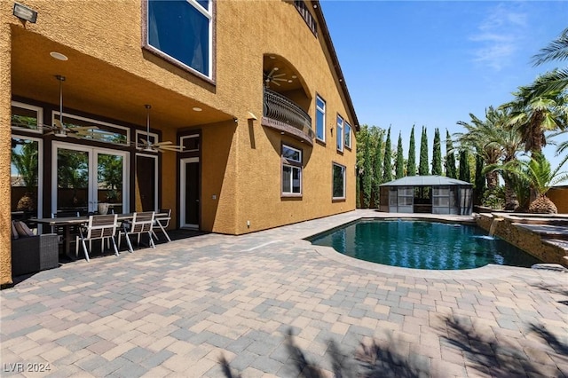 view of pool with pool water feature, ceiling fan, and a patio