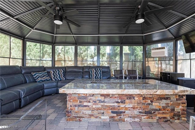 sunroom with an AC wall unit, ceiling fan, and lofted ceiling