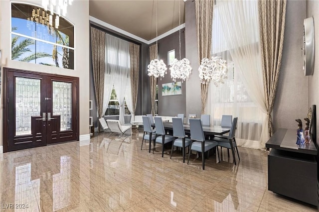 dining room with a high ceiling, french doors, an inviting chandelier, crown molding, and a wealth of natural light