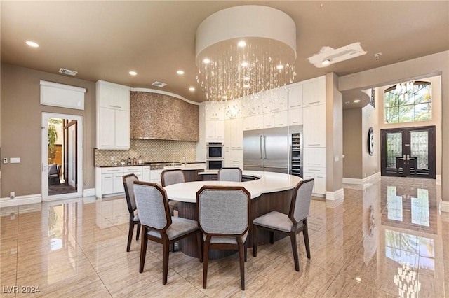 dining space featuring a chandelier, french doors, and a high ceiling