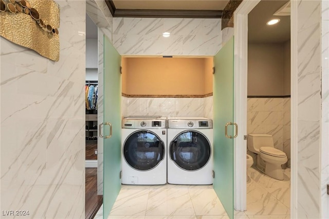 washroom featuring washer and dryer, tile walls, and ornamental molding