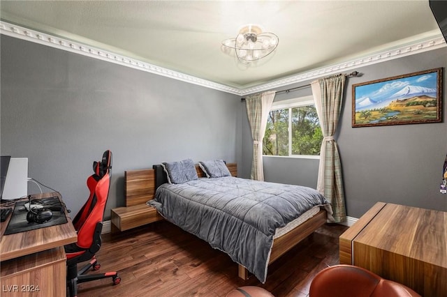 bedroom with dark hardwood / wood-style floors and ornamental molding