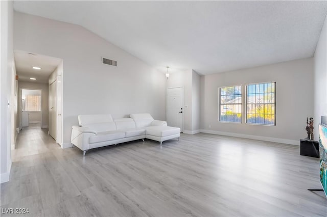 living room with light hardwood / wood-style flooring and vaulted ceiling