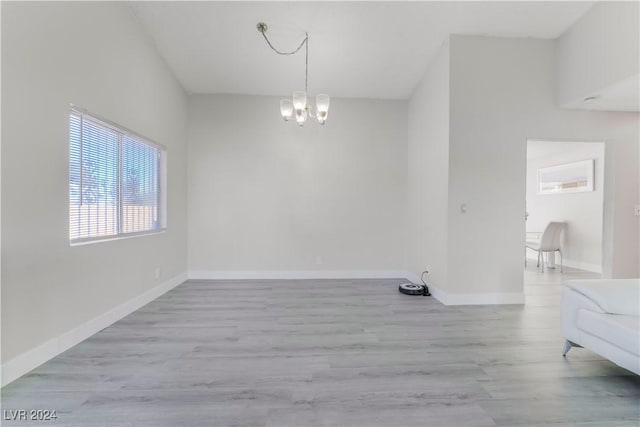 unfurnished dining area with light hardwood / wood-style flooring and a notable chandelier