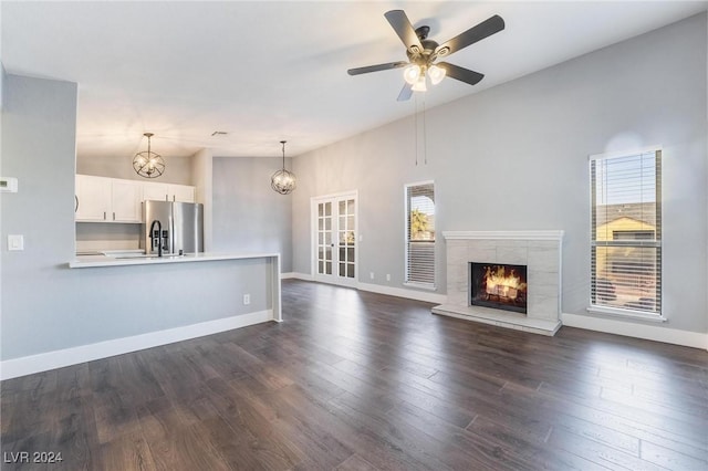 unfurnished living room featuring a wealth of natural light, a fireplace, ceiling fan, and lofted ceiling