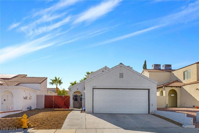 view of front of property featuring a garage, fence, driveway, a gate, and stucco siding