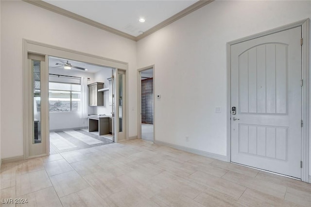 entrance foyer featuring ceiling fan and ornamental molding