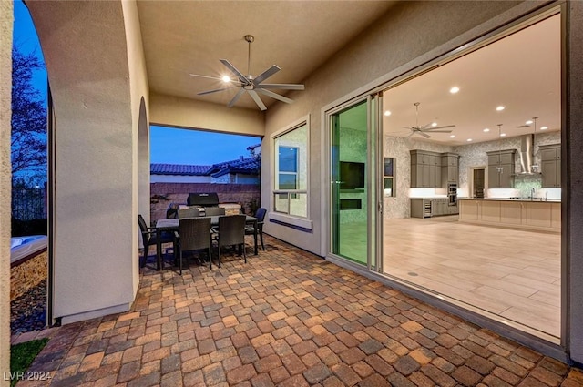 view of patio / terrace with ceiling fan, sink, and exterior kitchen