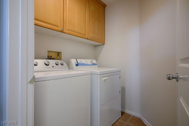 washroom with cabinets, tile patterned flooring, and washing machine and clothes dryer