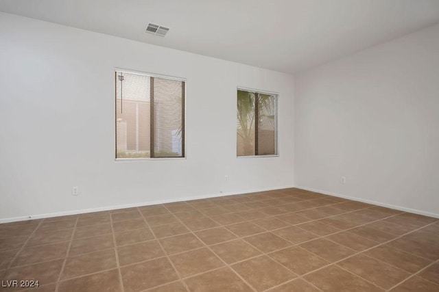 empty room featuring baseboards and visible vents