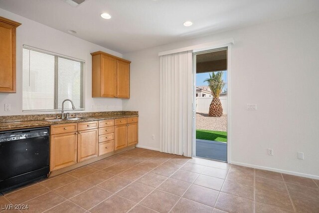 kitchen with stone counters, sink, black dishwasher, and light tile patterned floors