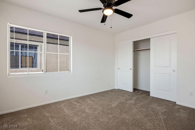 unfurnished bedroom featuring dark colored carpet, ceiling fan, and a closet