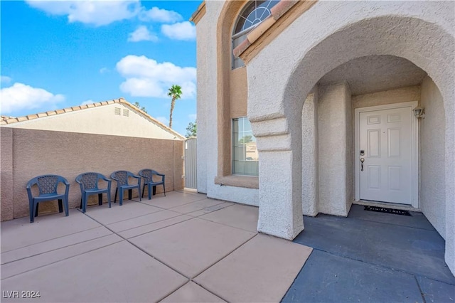 view of exterior entry with a patio area