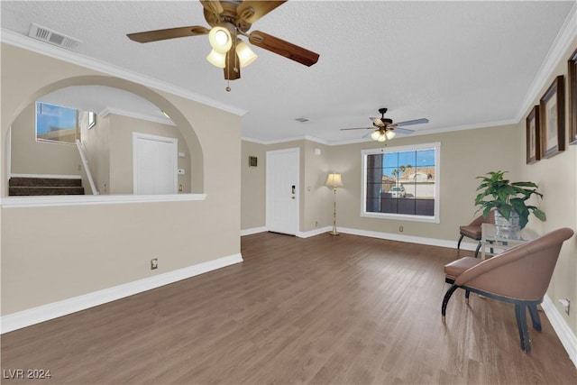 unfurnished room with a textured ceiling, dark hardwood / wood-style flooring, ceiling fan, and crown molding