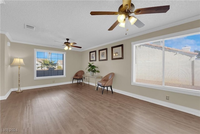 unfurnished room featuring crown molding, ceiling fan, wood-type flooring, and a textured ceiling